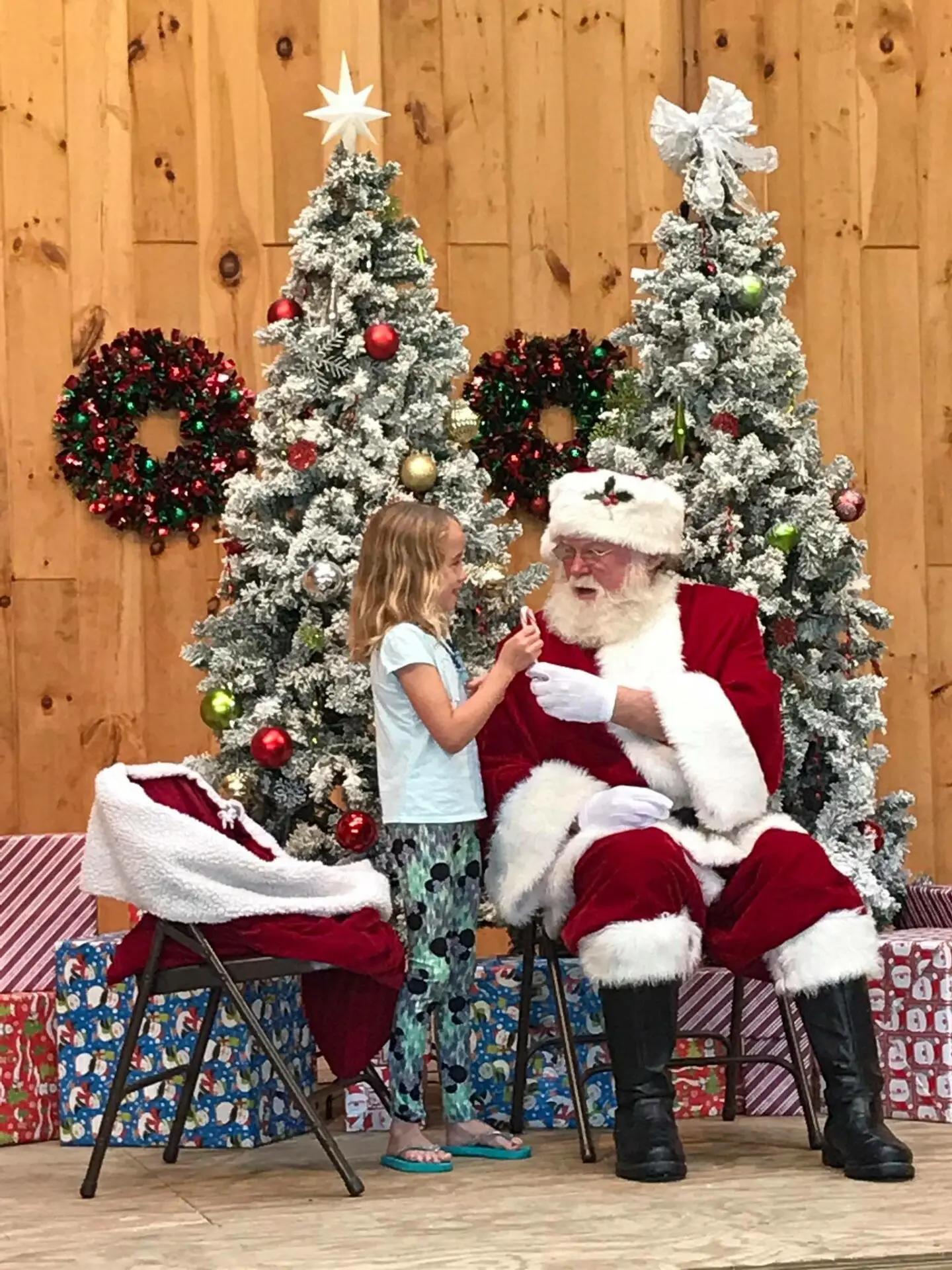 Girl getting candy cane from santa
