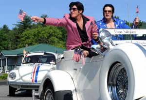 Elvis impersonators in classic white car